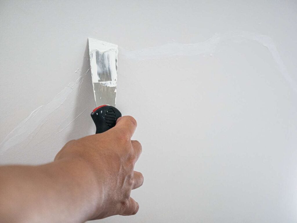 plasterer hand repair crack white wall